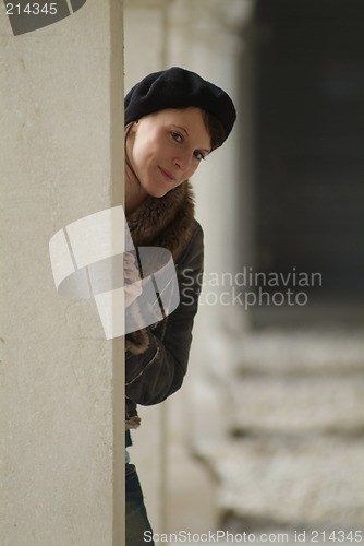 Image of young woman leans at a pillar