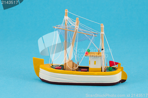 Image of wooden handmade boat ship model on blue background 