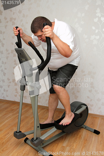 Image of overweight man exercising on trainer