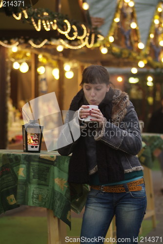 Image of junge Frau am Glühweinstand | young woman drinks glogg