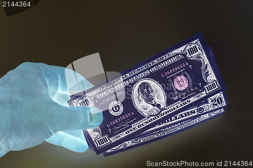 Image of hand holding US dollars in negative colors