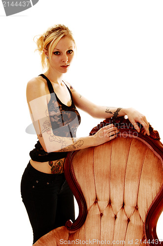 Image of Girl standing on armchair.