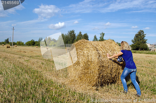 Image of woman jeans move push straw bale agriculture field 