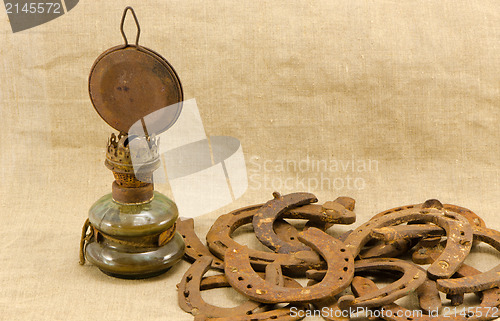 Image of retro kerosene lamp rusty horse shoes linen 