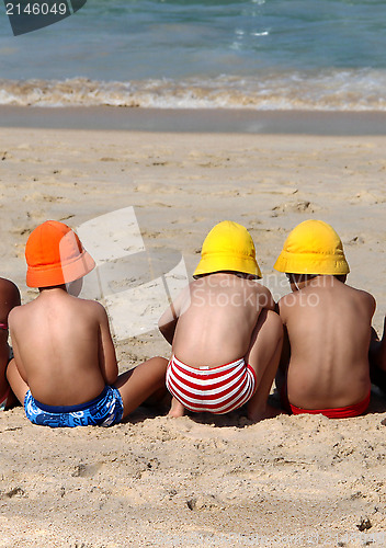 Image of Three cute small children playing on the beach