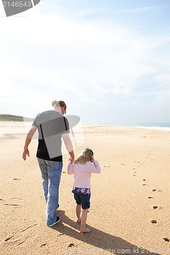 Image of Father and daughter walking at the beach