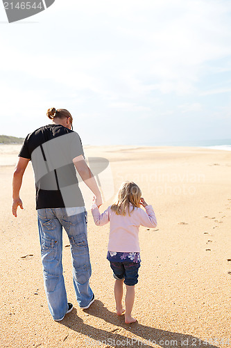 Image of Father and daughter walking at the beach