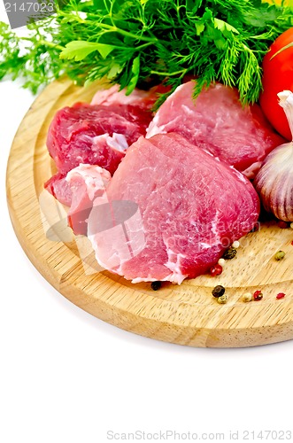 Image of Meat slices on a round plate with vegetables and herbs