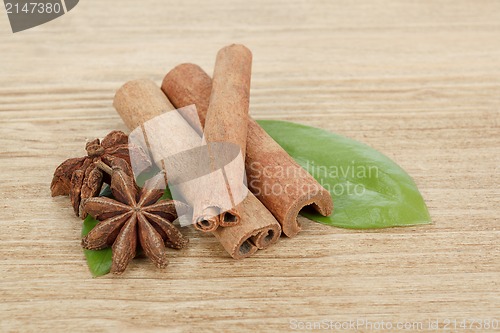 Image of Star Anise, cinnamon and and green leave on wood
