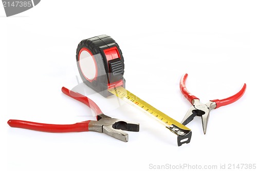 Image of red pliers and measuring tape isolated on white
