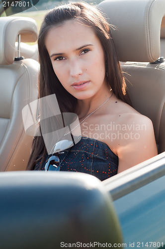 Image of Beautiful brunette woman sitting in the car