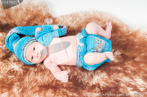 Image of Newborn baby in knitted blue clothes
