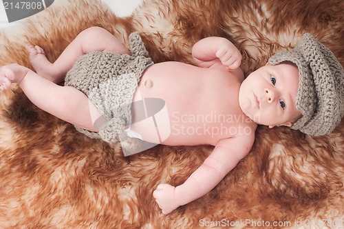 Image of Newborn baby in knitted blue clothes
