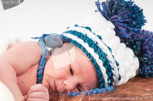 Image of Newborn baby in knitted hat with pom-pons