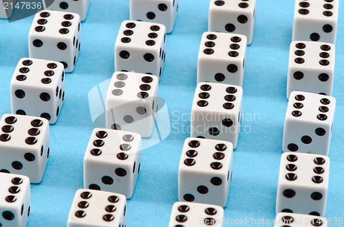 Image of white gamble dice black dots blue background 