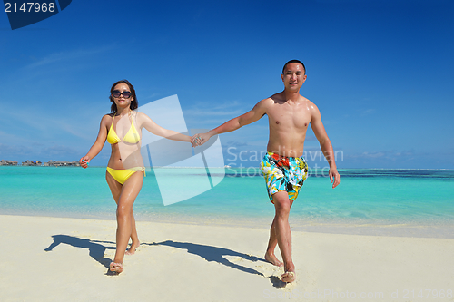 Image of happy young  couple enjoying summer on beach