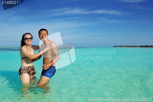 Image of happy young  couple enjoying summer on beach