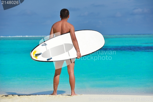 Image of Man with surf board on beach