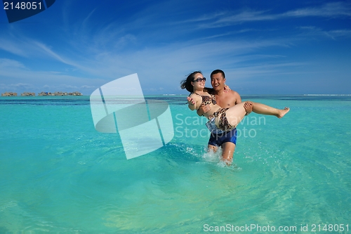 Image of happy young  couple enjoying summer on beach