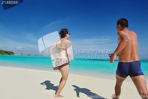 Image of happy young  couple enjoying summer on beach