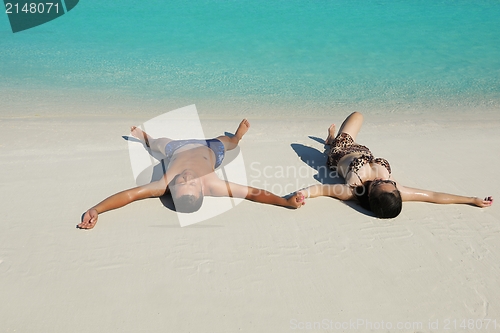 Image of happy young  couple enjoying summer on beach