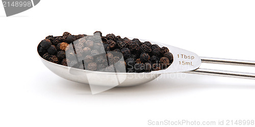 Image of Black peppercorns measured in a metal tablespoon