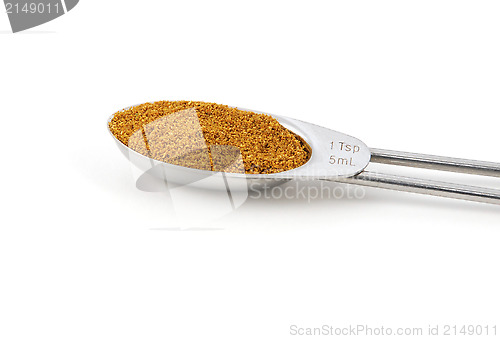 Image of Curry powder measured in a metal teaspoon