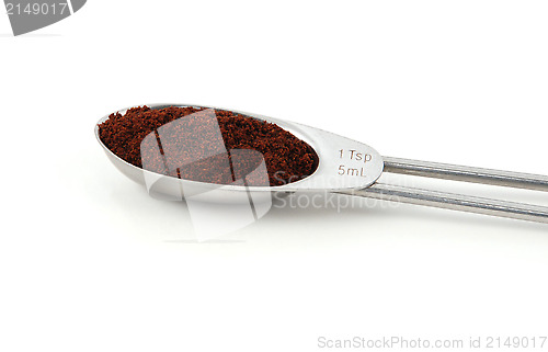 Image of Ground cloves measured in a metal teaspoon