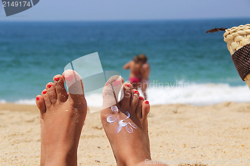 Image of Female feet on the beach 