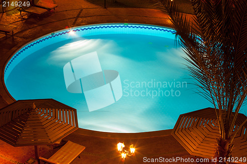 Image of Nighttime setting of a luxury villa poolside