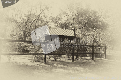 Image of Sepia Wooden Dollhouse in Garden