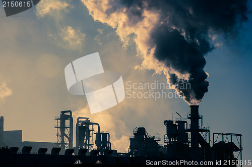 Image of Smoking chimney  at sunset 