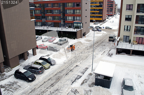 Image of tractor clean winter snow in flat house parking 