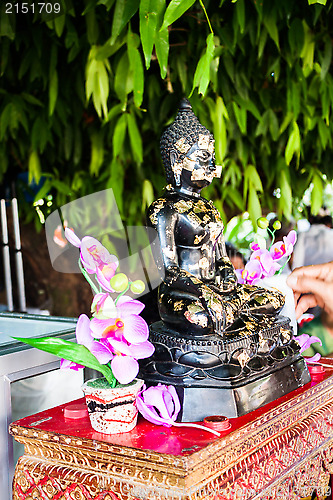 Image of Buddhist covering buddha image with gold leafs