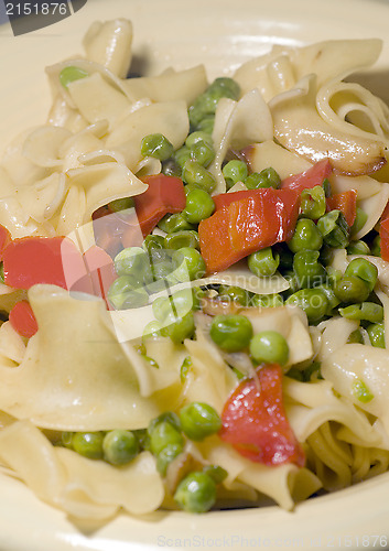 Image of noodles with green peas red pepper pieces and garlic butter