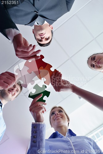 Image of Group of business people assembling jigsaw puzzle