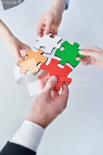 Image of Group of business people assembling jigsaw puzzle