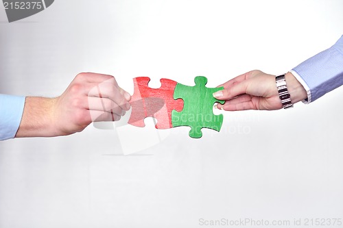 Image of Group of business people assembling jigsaw puzzle