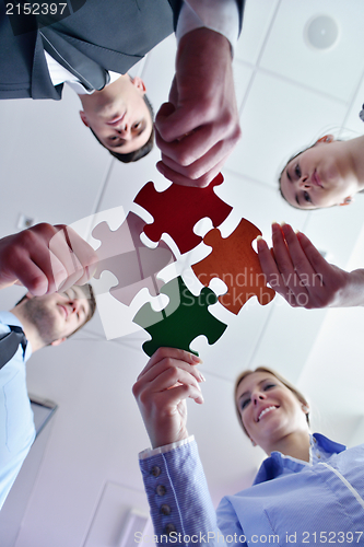 Image of Group of business people assembling jigsaw puzzle