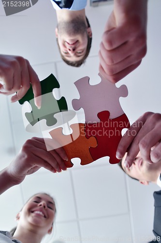 Image of Group of business people assembling jigsaw puzzle