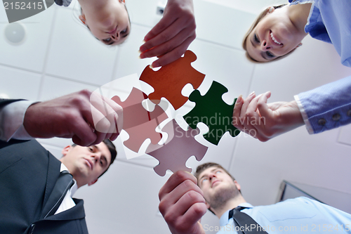 Image of Group of business people assembling jigsaw puzzle