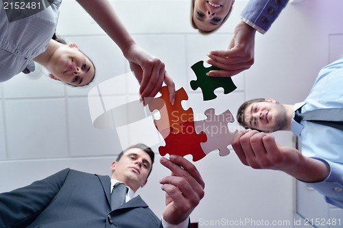 Image of Group of business people assembling jigsaw puzzle