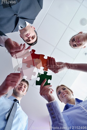 Image of Group of business people assembling jigsaw puzzle