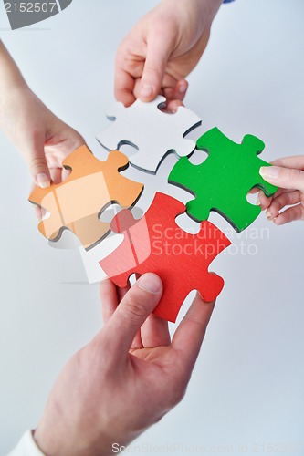 Image of Group of business people assembling jigsaw puzzle