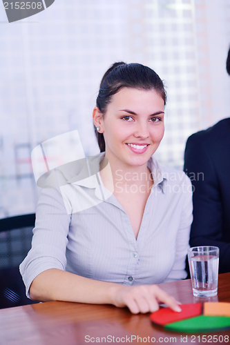 Image of business woman with her staff in background at office