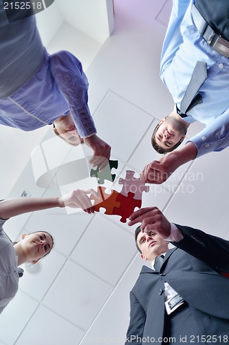 Image of Group of business people assembling jigsaw puzzle