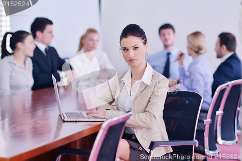 Image of business woman with her staff in background at office