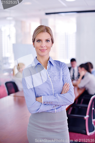 Image of business woman with her staff in background at office