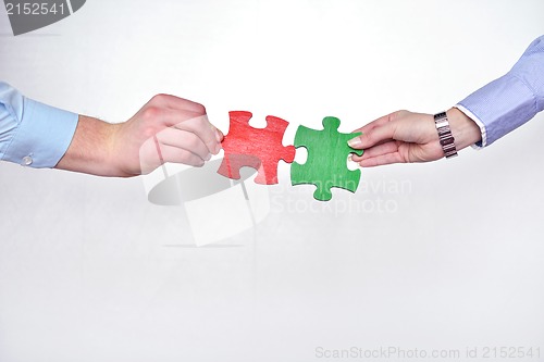 Image of Group of business people assembling jigsaw puzzle