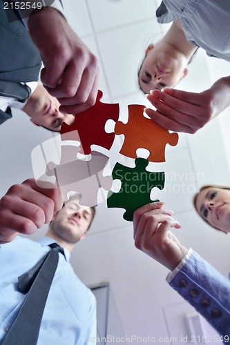 Image of Group of business people assembling jigsaw puzzle